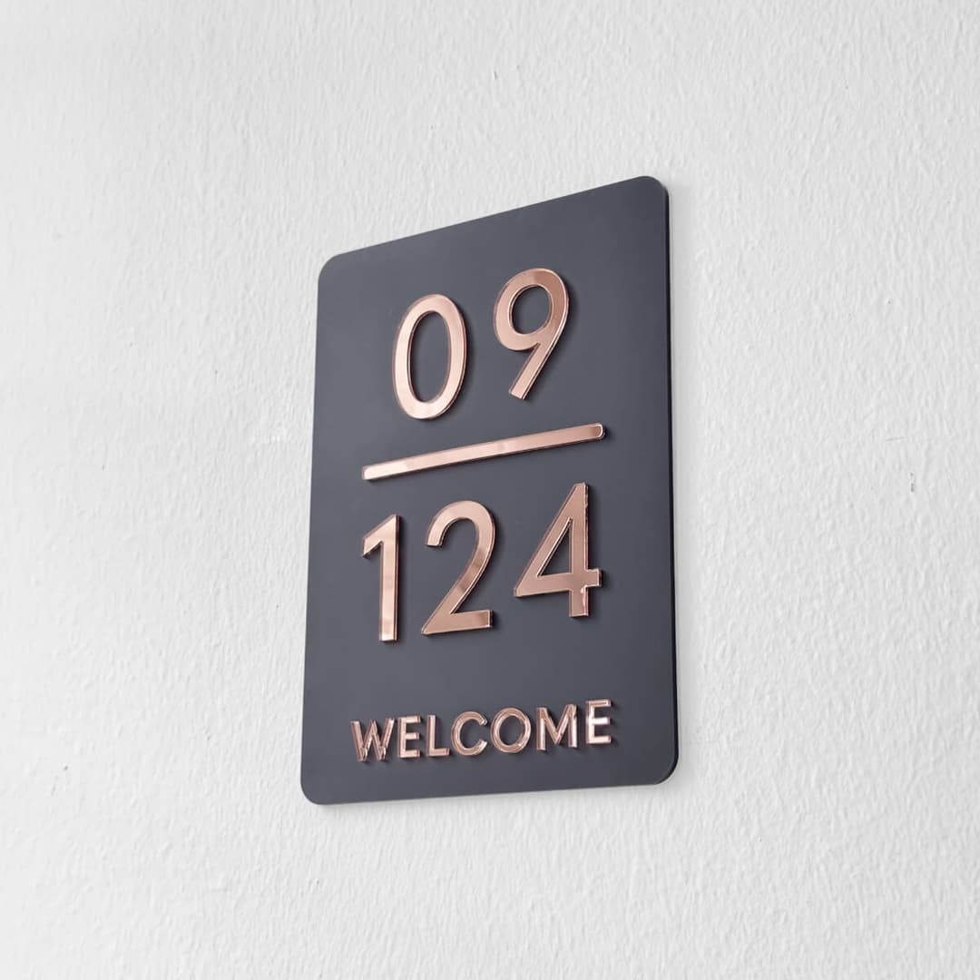 Blissbies HARPER Style 2 unit sign in dark grey with rose gold numbers, the storey 09 above a line and the unit 124 below, with WELCOME underneath