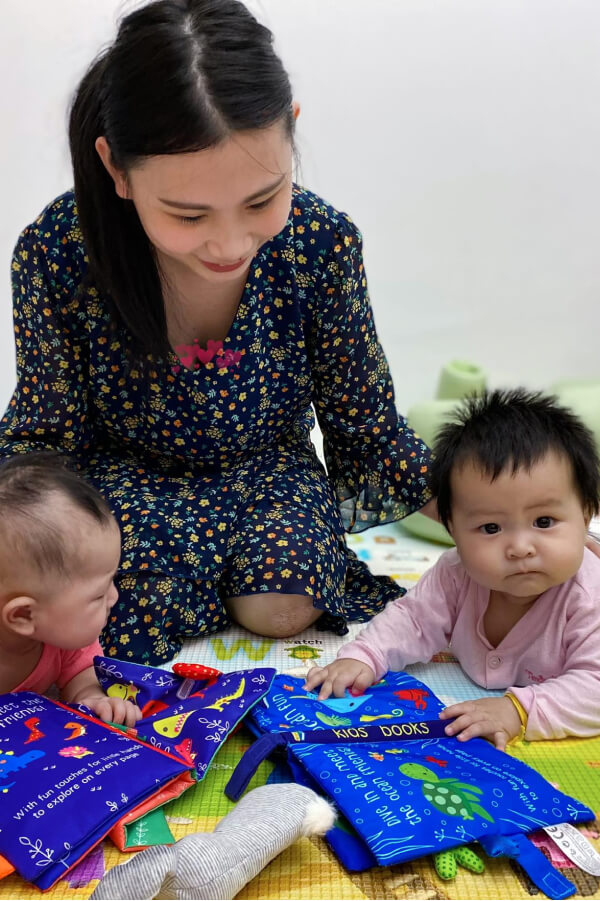 Testimonial photo - mommy and baby boy and girl playing with our newborn cloth book